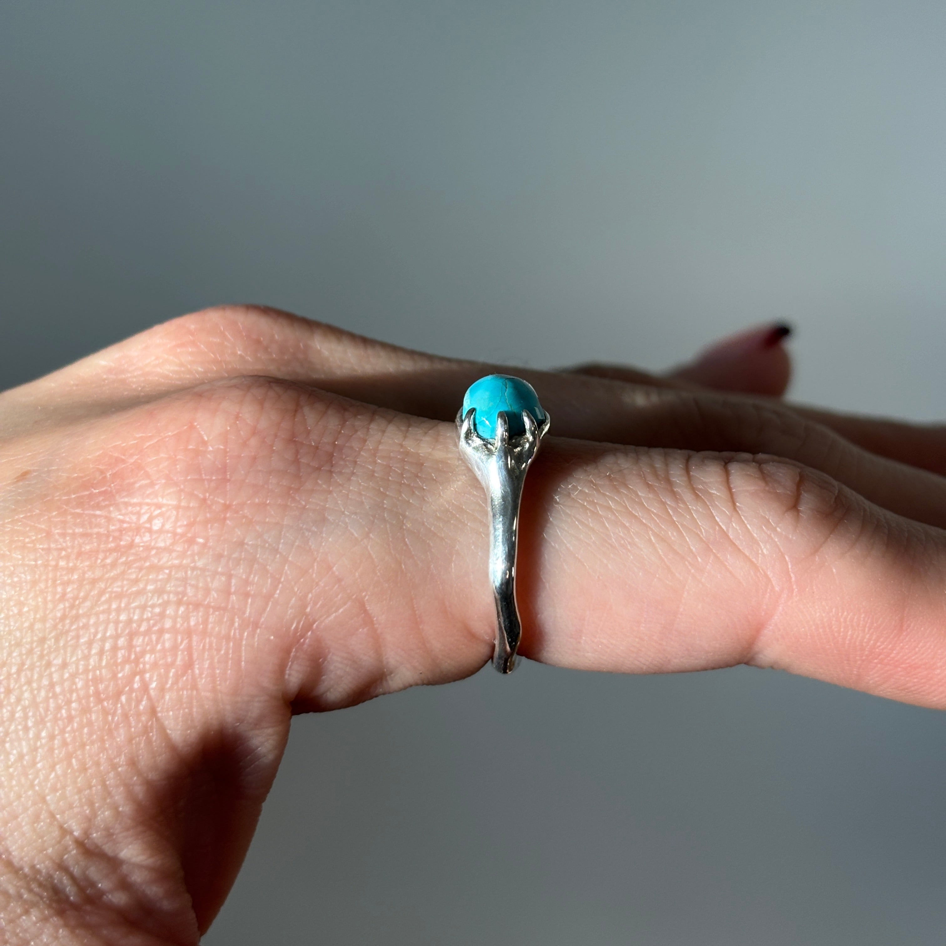 silver and turquoise ring on a hand (sideview)