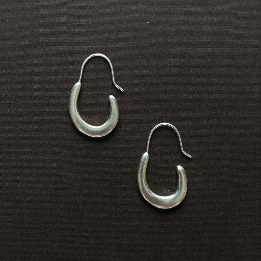 Pair of silver hoop earrings on a brown background