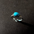 Silver ring with a turquoise stone on a brown background