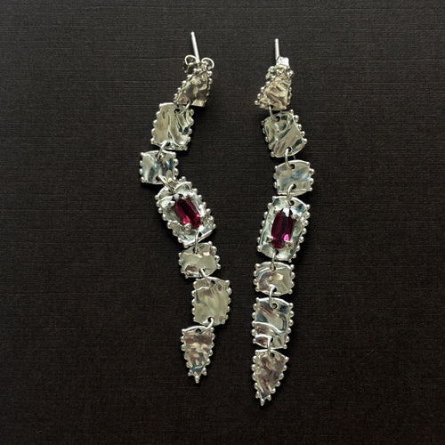 pair of sterling silver long drop earrings  with elongated rhodolite garnets (deep purple/pink) brown background 